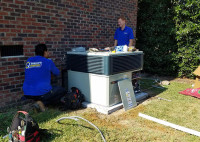 two Quality techs working on ac unit