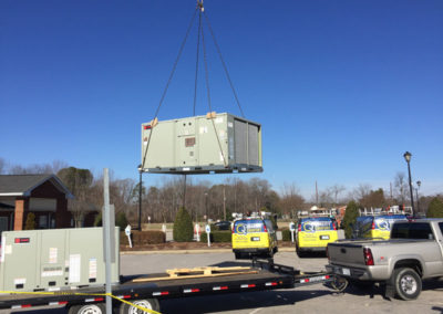 large hvac unit being lifted off truck